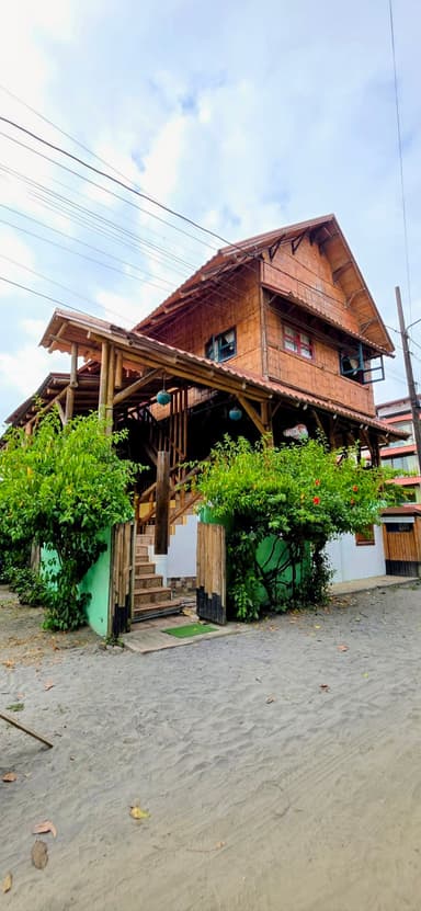 Une maison en bois entourée de verdure sous un ciel nuageux.