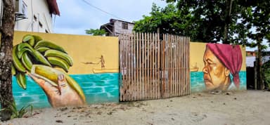 Une fresque murale colorée représentant des bananes et un homme sur un bateau.