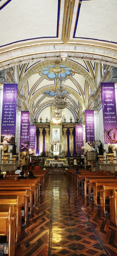 Une église avec des bancs en bois et des décorations colorées.