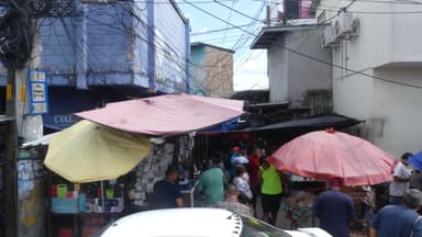 Une rue animée avec des parasols colorés et des gens qui se déplacent.