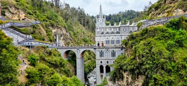 Une église majestueuse sur un pont au-dessus d'une vallée verdoyante.
