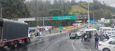Une route avec des véhicules et un panneau indiquant la Colombie.