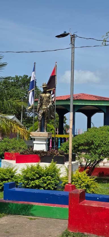 Une statue avec des drapeaux dans un parc à Chontales.