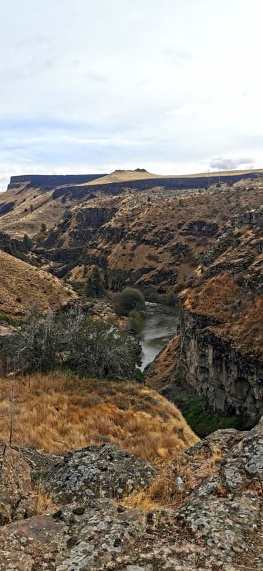 Un paysage de collines sèches et d'une rivière en Oregon.