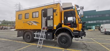 Un véhicule tout-terrain jaune stationné dans un parking.