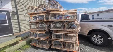Des cages à homards empilées sous un ciel bleu.