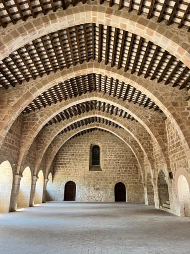 Intérieur d'un bâtiment historique avec des arches en pierre.