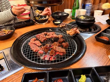 Grilled meat on a charcoal grill with side dishes in a restaurant.